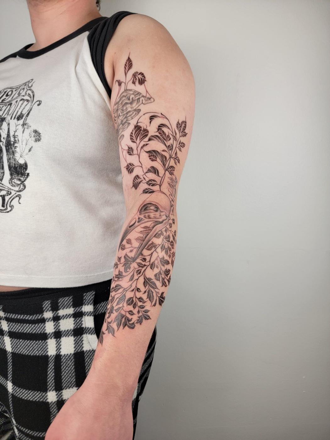 Fine line bird skull and fern tattoo