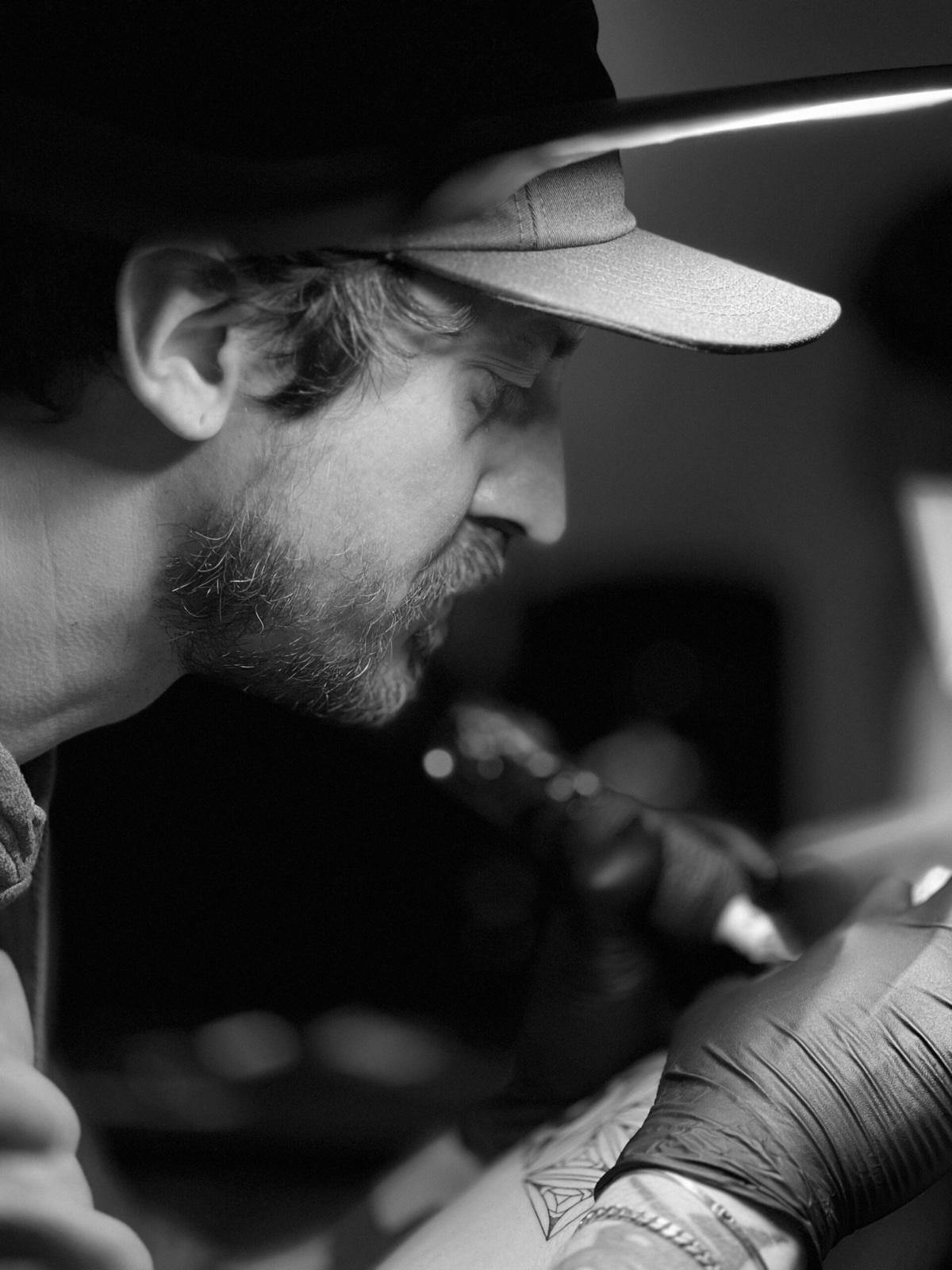 Emrah Ozhan, tattoo artist at B36 Tattoo & Piercing, tattooing a client