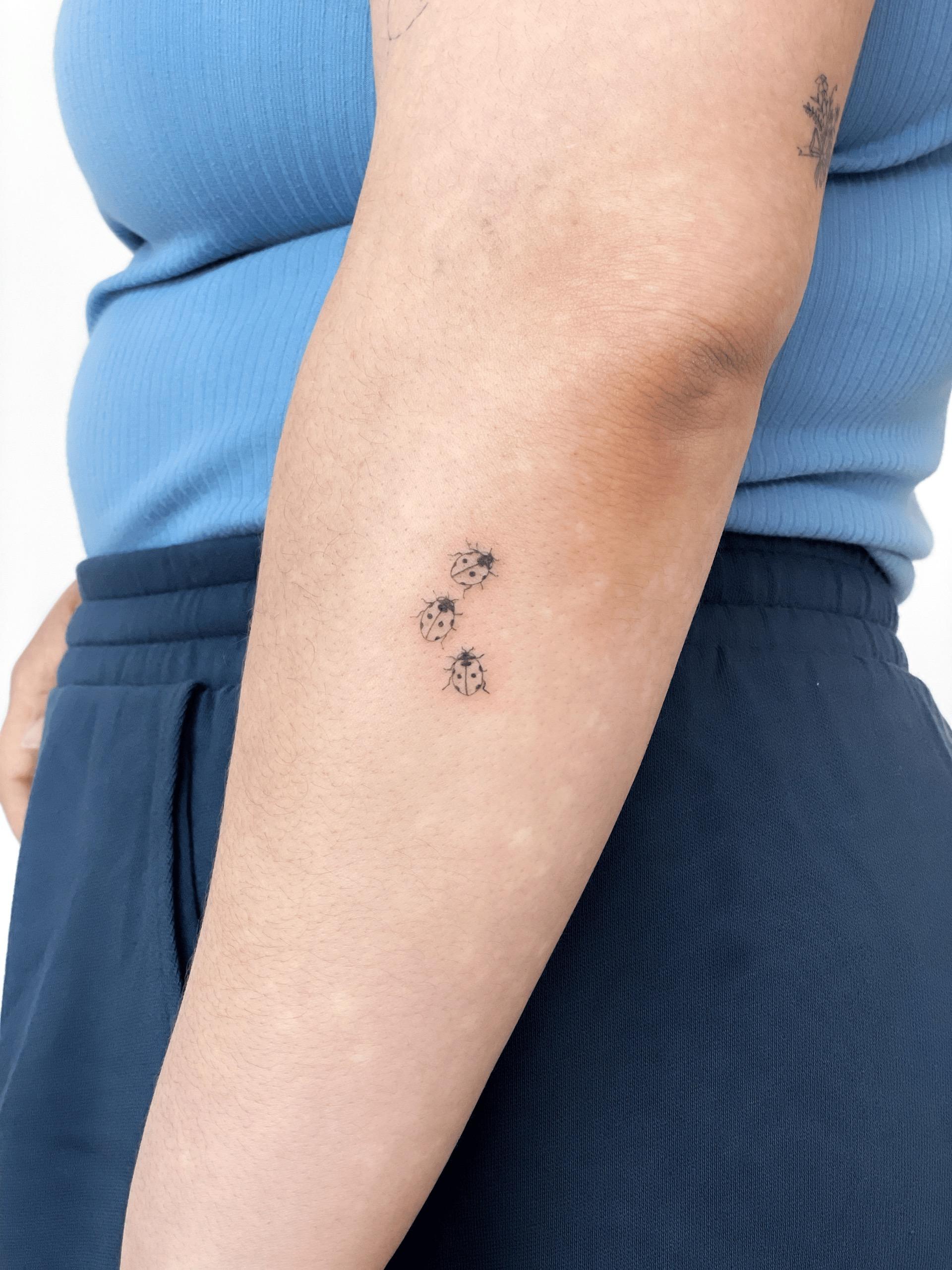 Fine line ladybug tattoo