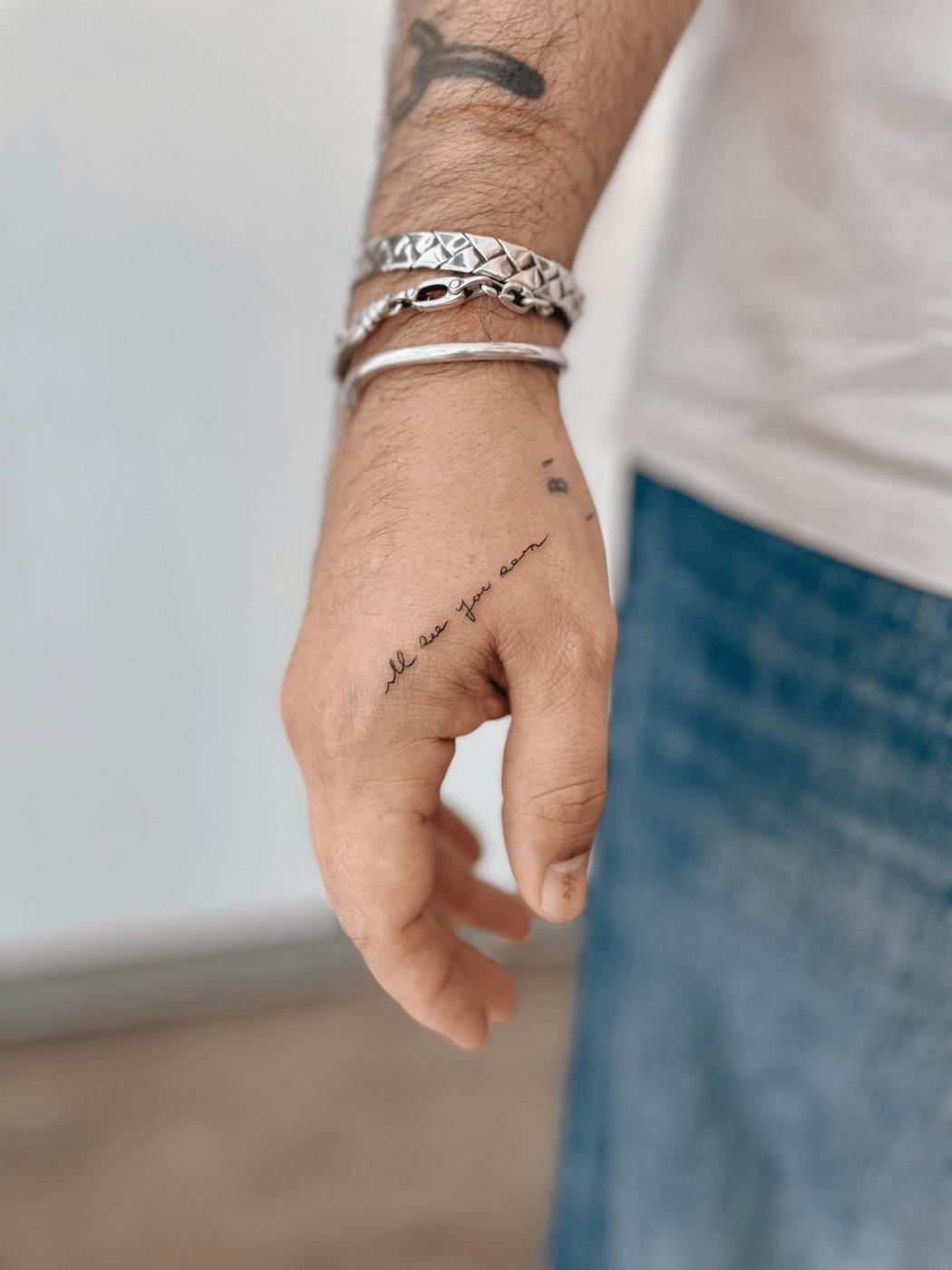 Script tattoo on hand