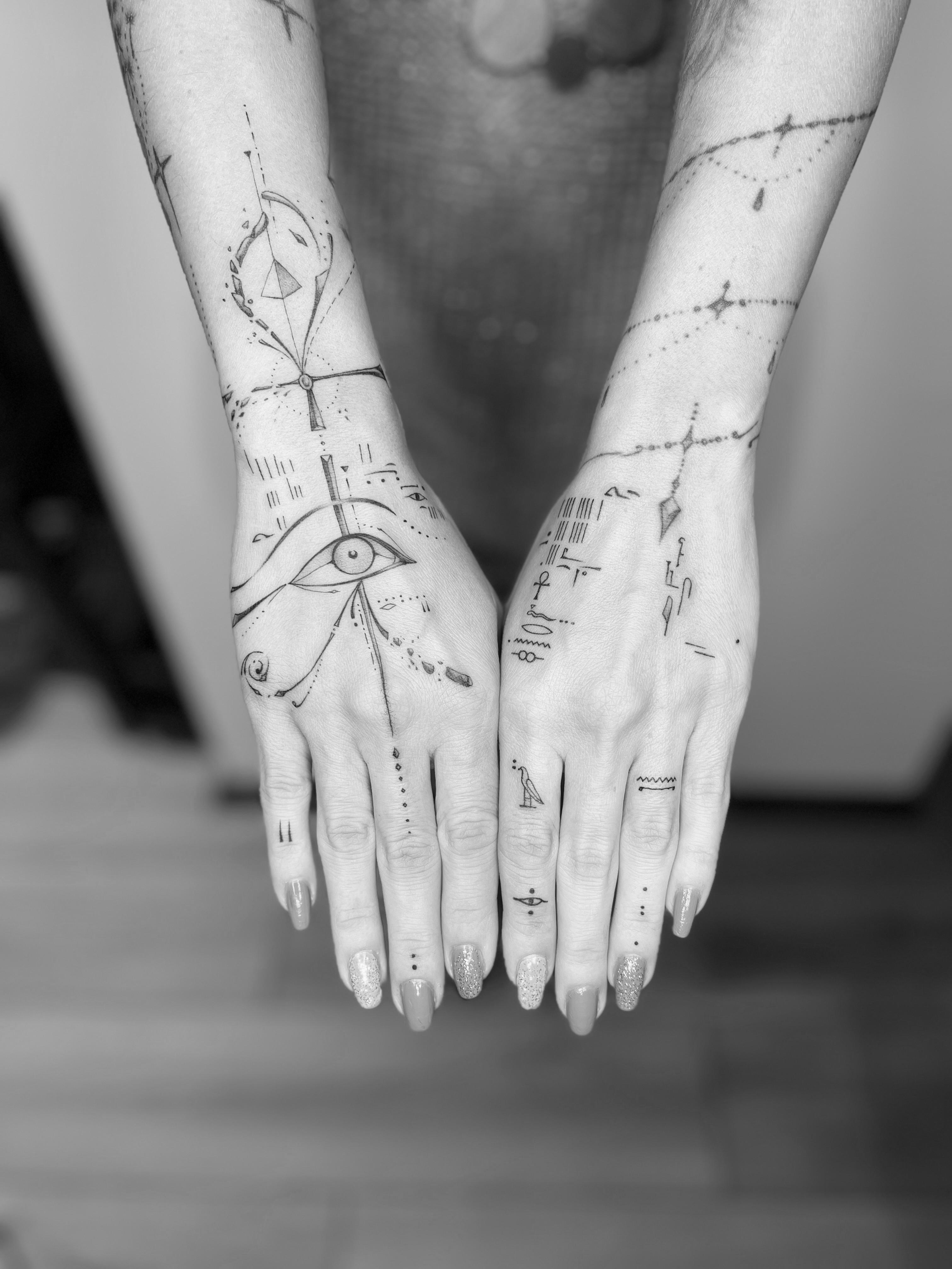 Black and grey Egyptian symbol tattoos on the hands