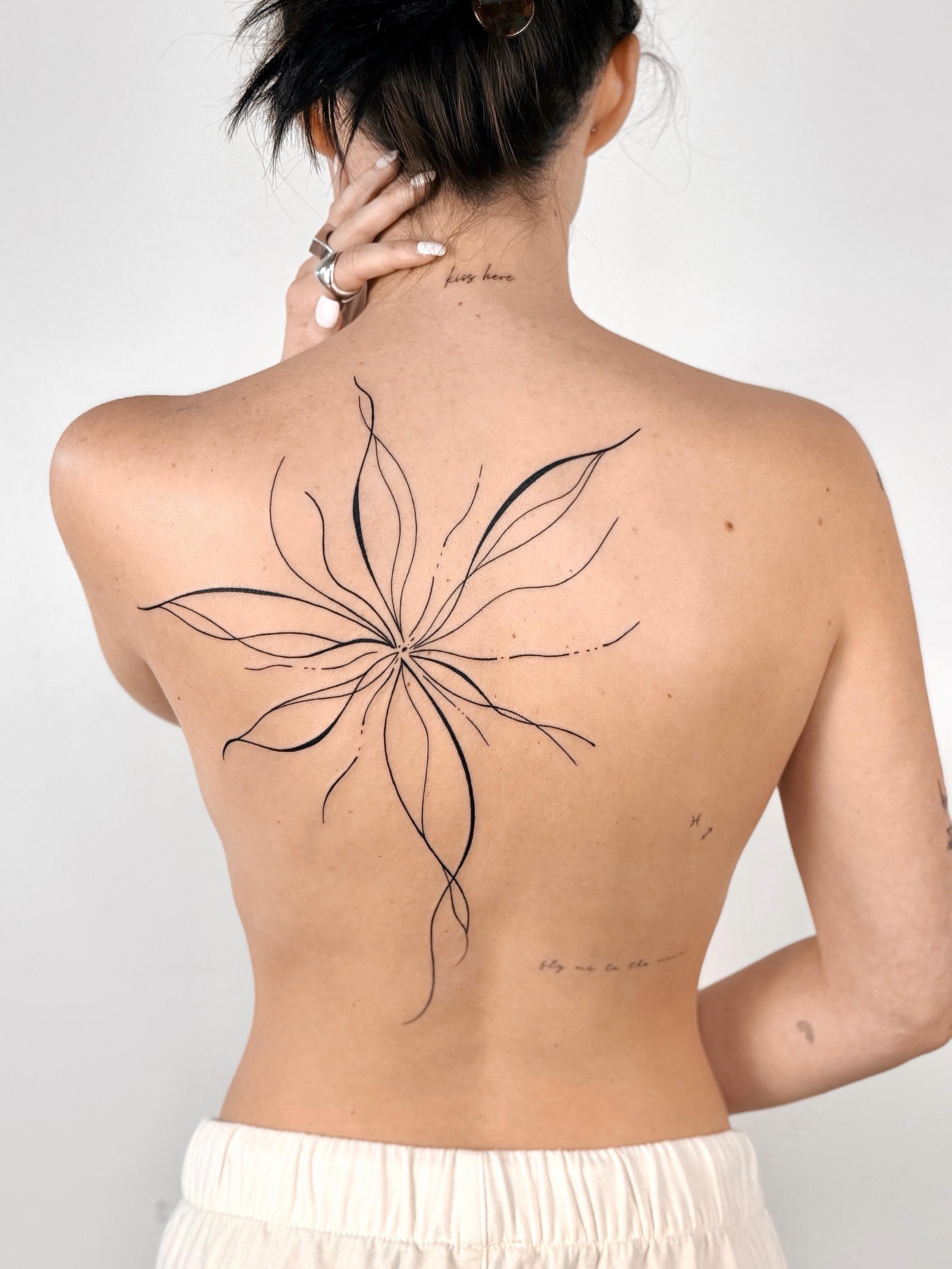 Blackwork botanical back tattoo