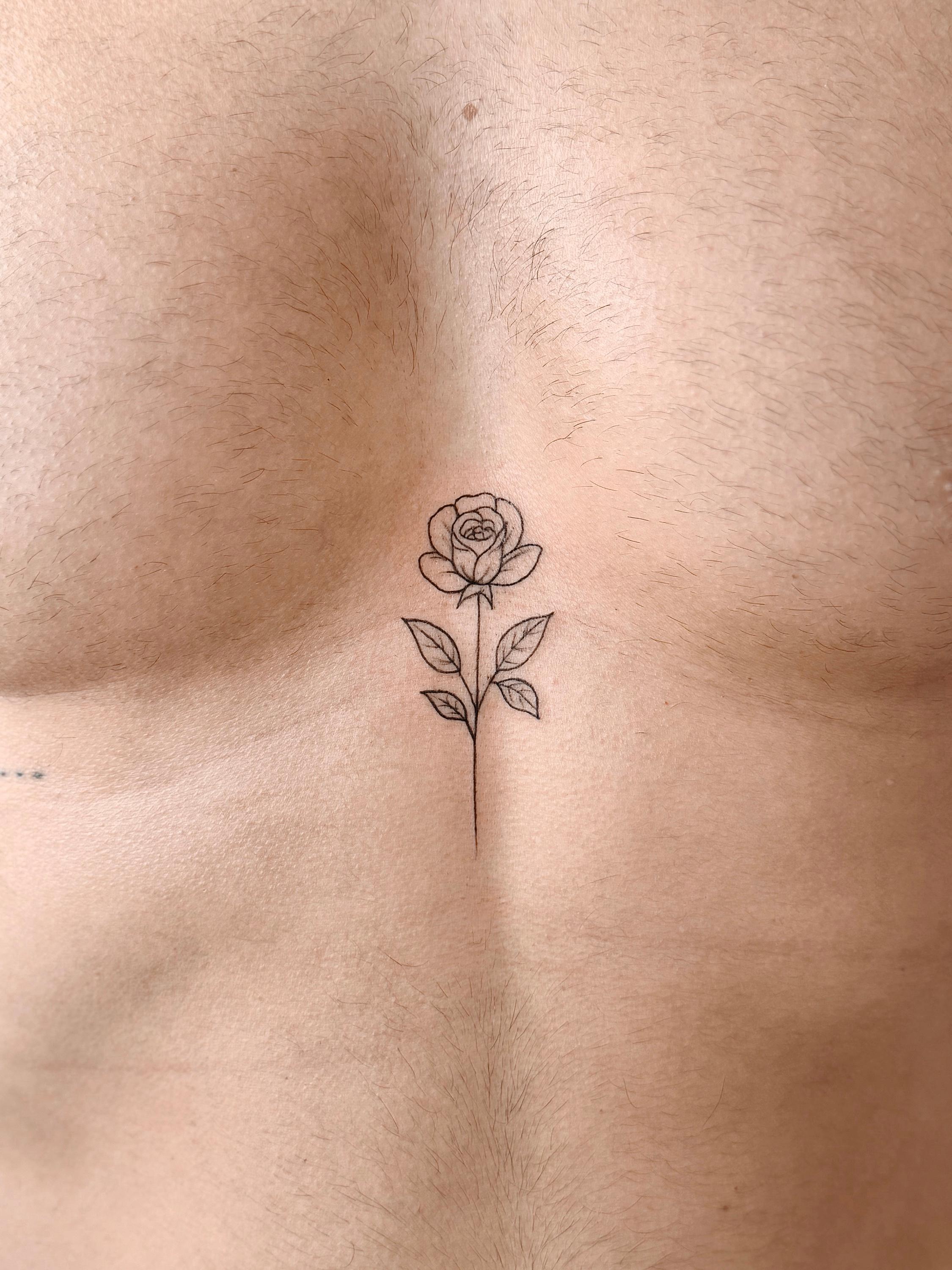 Fine line rose tattoo on the sternum