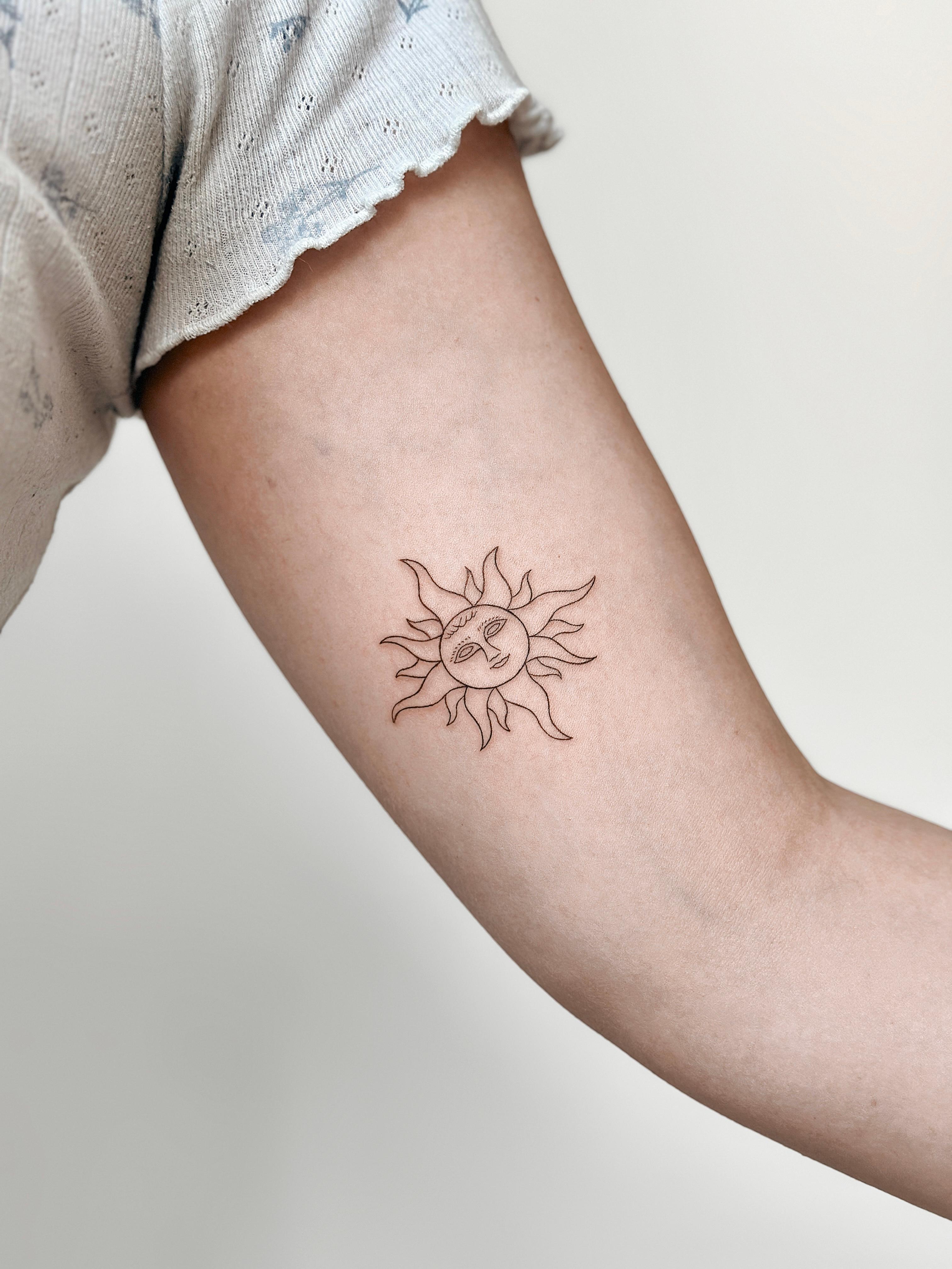 Fine line sun face tattoo