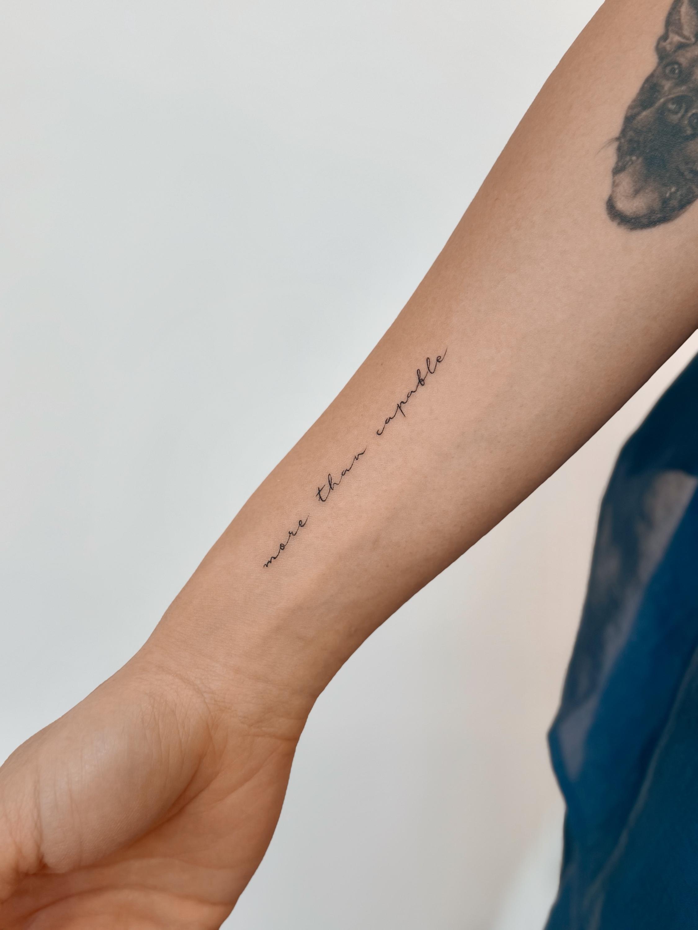 Fine line cursive tattoo reading more than capable