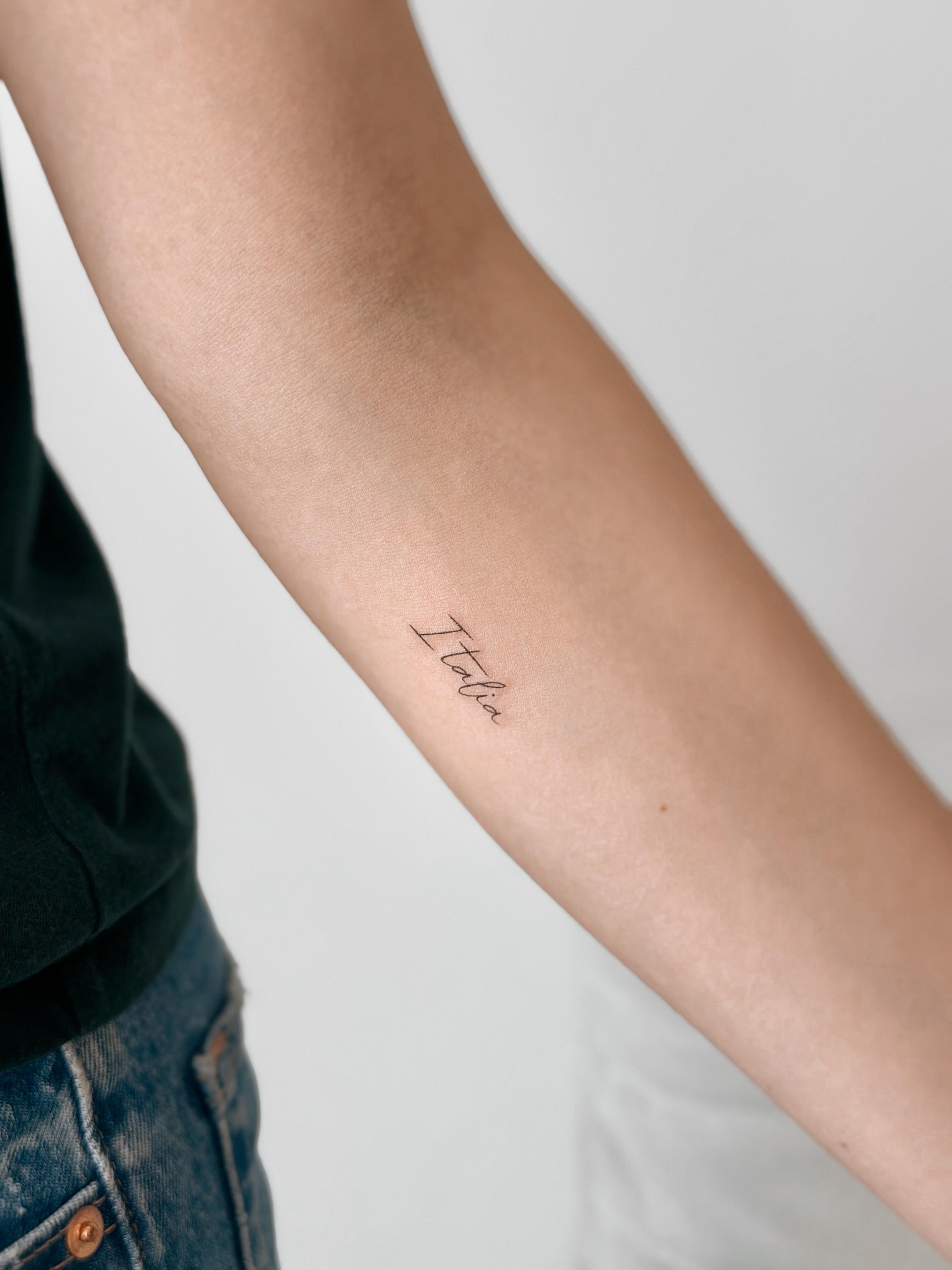 Fine line script tattoo reading Italia