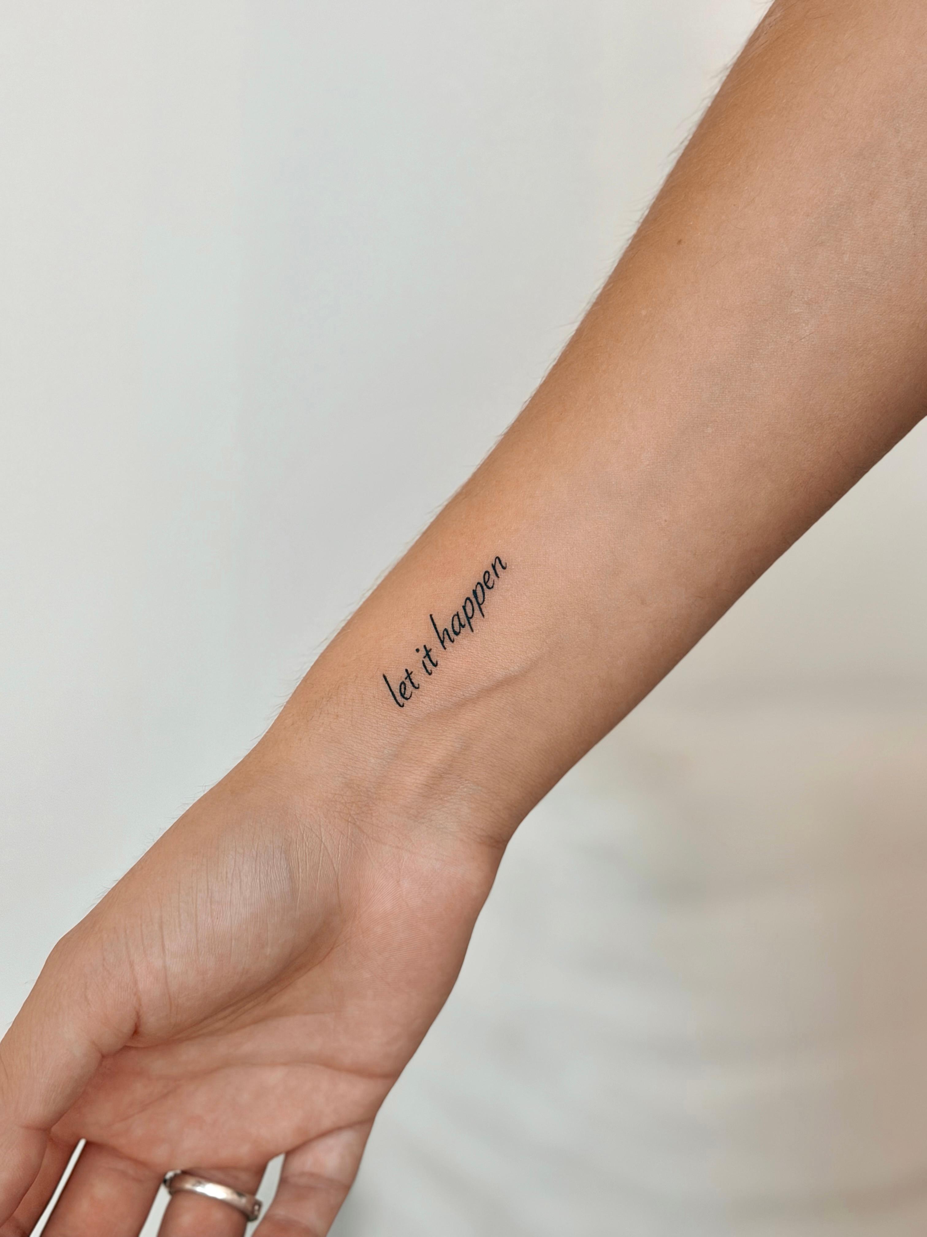 Fine line lettering tattoo reading let it happen